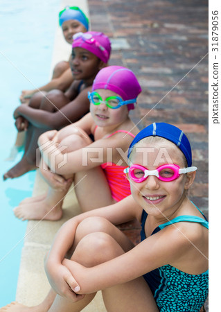Little swimmers sitting at poolside 31879056