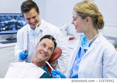 Dentists interacting with a male patient 31879562