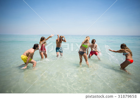 Couples splashing water while enjoying in sea 31879658