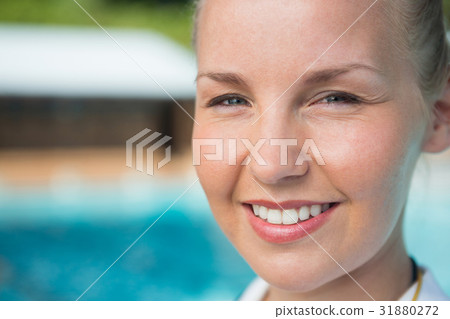 Smiling female coach standing near poolside Smiling female coach standing near poolside 31880272