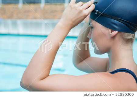Fit woman wearing swimming goggle in pool 31880300