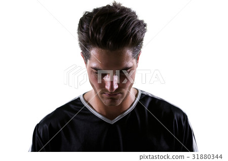 Upset football player looking down 31880344