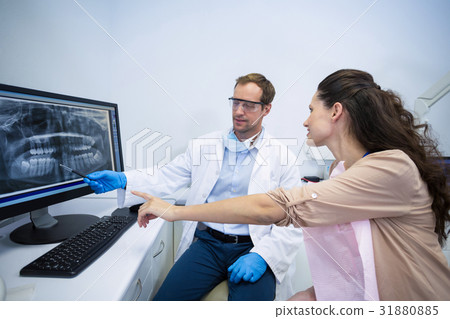 Dentist showing an x-ray of teeth to female patient Dentist showing an x-ray of teeth to female patient 31880885