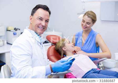 Dentist holding digital tablet in dental clinic Dentist holding digital tablet in dental clinic 31880887