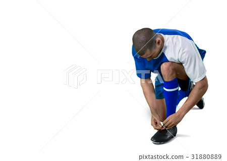 Football player tying his shoe lace Football player tying his shoe lace 31880889