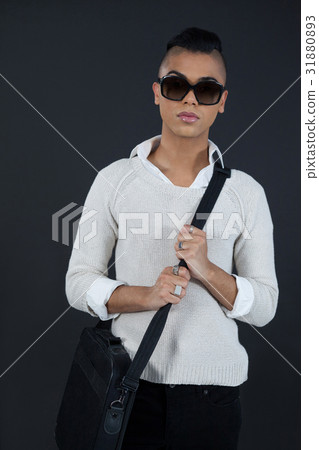 Transgender woman with bag against black background Transgender woman with bag against black background 31880893