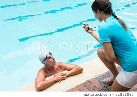 Swim coach interacting with senior man Swim coach interacting with senior man 31881085