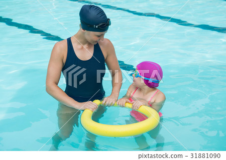 Female instructor training young girl in pool Female instructor training young girl in pool 31881090