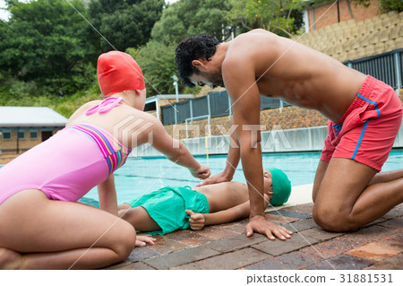 Lifeguard assisting unconscious boy while interacting with girl Lifeguard assisting unconscious boy while interacting with girl 31881531