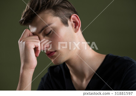 Tense androgynous man with hand on forehead 31881597