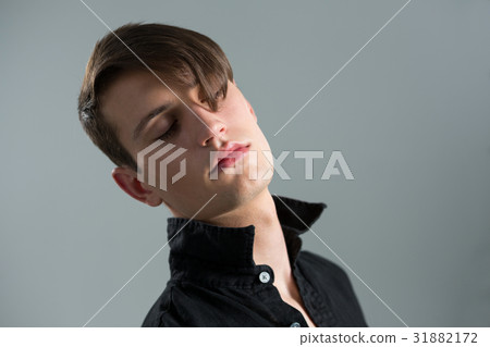 Androgynous man posing with eyes closed 31882172