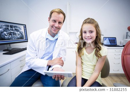 Portrait of smiling dentist and young patient 31882255