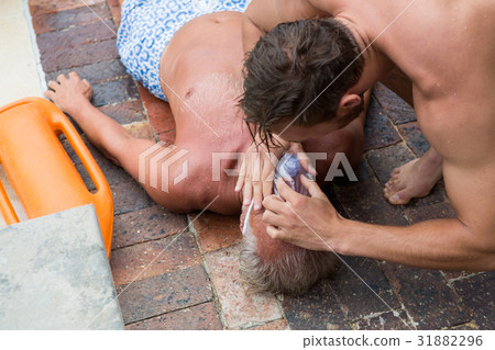Lifeguard helping unconscious senior man Lifeguard helping unconscious senior man 31882296