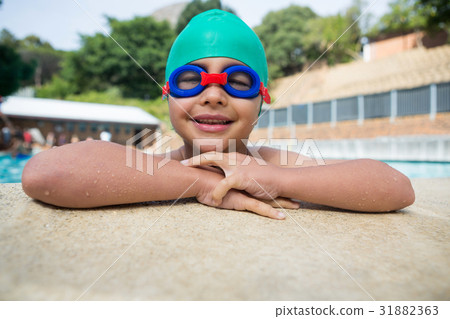 Smiling boy leaning on poolside 31882363