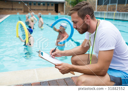 Swim coach writing on clipboard 31882552