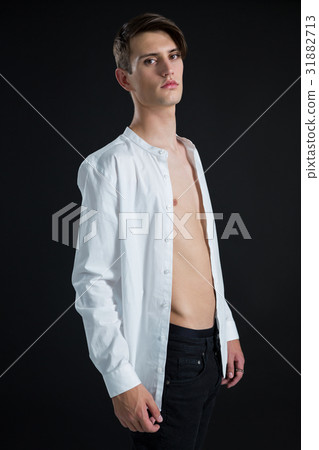 Androgynous man posing in open buttondown shirt Androgynous man posing in open buttondown shirt 31882713