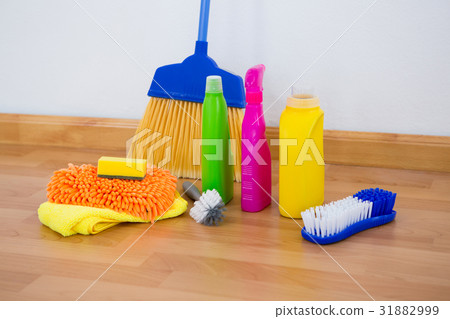 Chemical bottles by brush and sponges with broom on floor 31882999