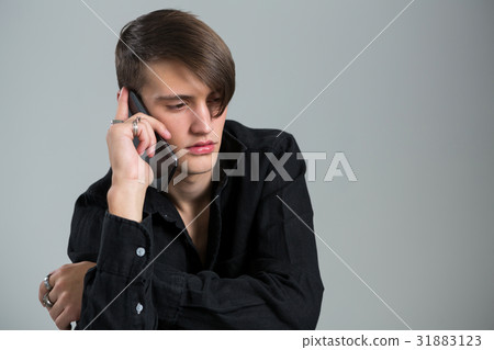 Androgynous man talking on his mobile phone 31883123