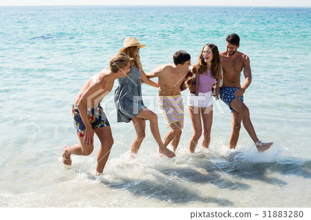 Cheerful friends dancing in sea Cheerful friends dancing in sea 31883280