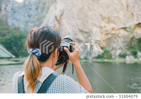 travel photographer with camera while shooting travel photographer with camera while shooting 31884079