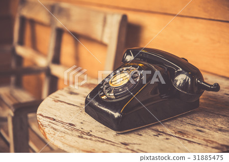 old telephone black color on wood table. old telephone black color on wood table. 31885475