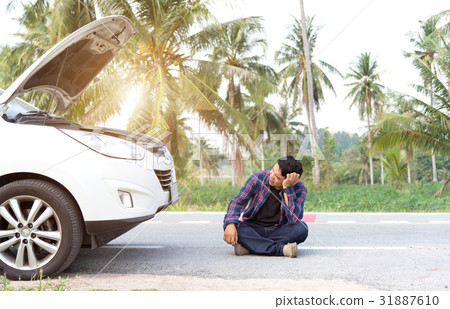 Stressed man sitting after a car breakdown at the Stressed man sitting after a car breakdown at the 31887610