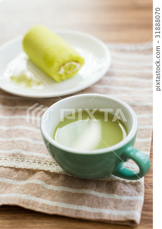 Roll cake with green tea on wooden table 31888070