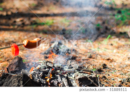 The sausage on the skewer is fried at the stake 31889311