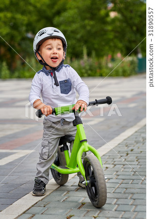 Child boy in white helmet riding on his first bike 31890557