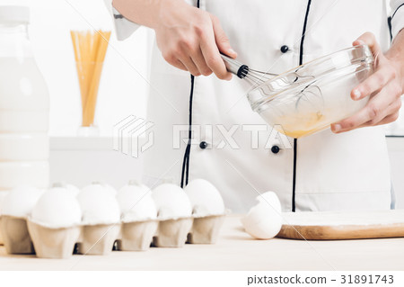 Chef in uniforms whipping eggs and milk in bowl in Chef in uniforms whipping eggs and milk in bowl in 31891743