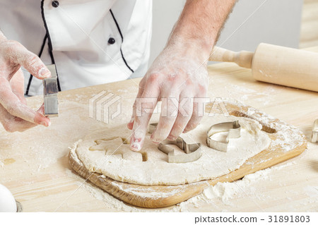 Man chef in uniform makes cookies with baking 31891803