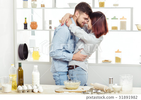 happy Couple in love cooking dough and kissing in happy Couple in love cooking dough and kissing in 31891982