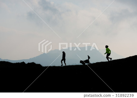 Two women race in the mountains with a dog Two women race in the mountains with a dog 31892239