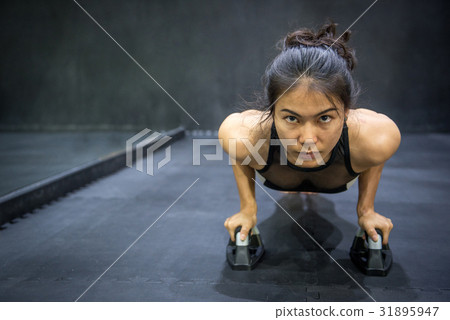Young Asian woman doing push up on the floor Young Asian woman doing push up on the floor 31895947