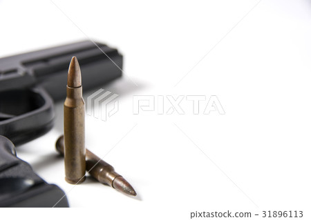 Hand gun sitting with m-16 bullets isolated. Hand gun sitting with m-16 bullets isolated. 31896113