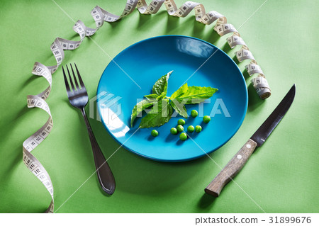 Diet blue plate with centimeter, basil and peas 31899676