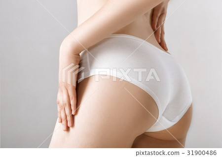 woman's ass in white lingerie on grey background - Stock Photo