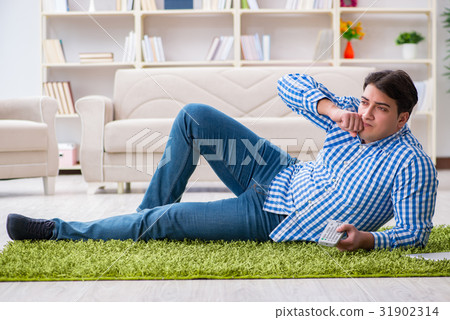 Young handsome man sitting on floor at home 31902314