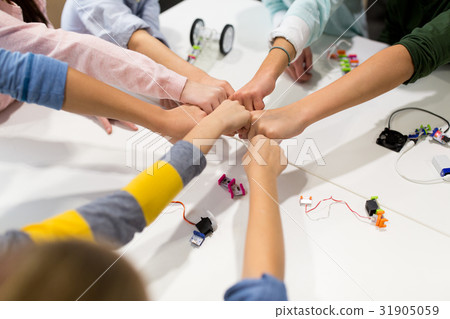 happy children making fist bump at robotics school 31905059
