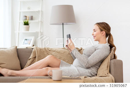 happy pregnant woman with tablet pc at home 31905067