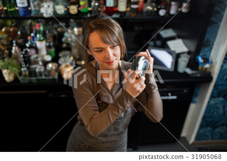 barmaid with shaker preparing cocktail at bar 31905068