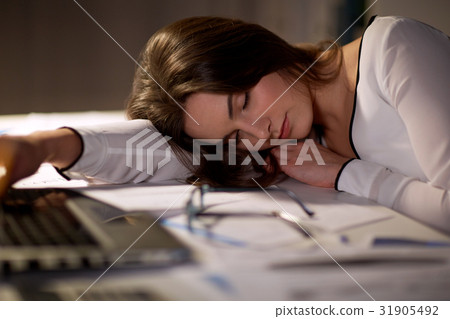 tired woman sleeping on office table at night tired woman sleeping on office table at night 31905492