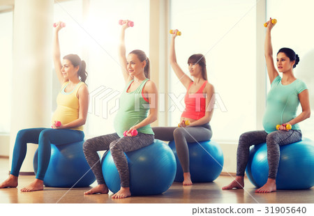 happy pregnant women exercising on fitball in gym happy pregnant women exercising on fitball in gym 31905640
