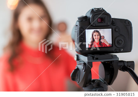 woman with bronzer and camera recording video 31905815