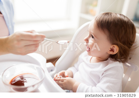 mother feeding baby with puree at home 31905829