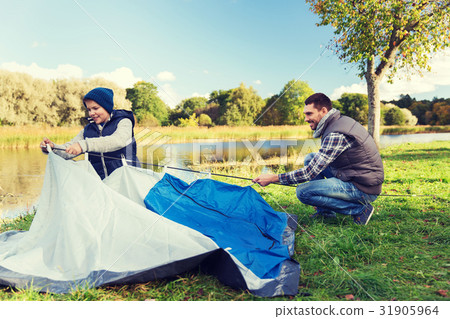 happy father and son setting up tent outdoors 31905964