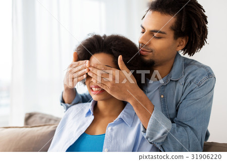 happy man closing woman eyes at home 31906220