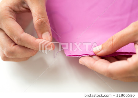 woman with needle stitching fabric pieces woman with needle stitching fabric pieces 31906580