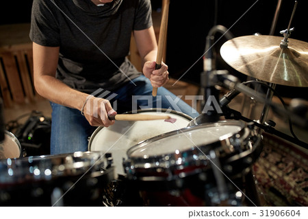 male musician playing drums and cymbals at concert 31906604