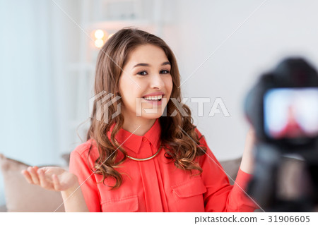 woman with camera recording video at home 31906605